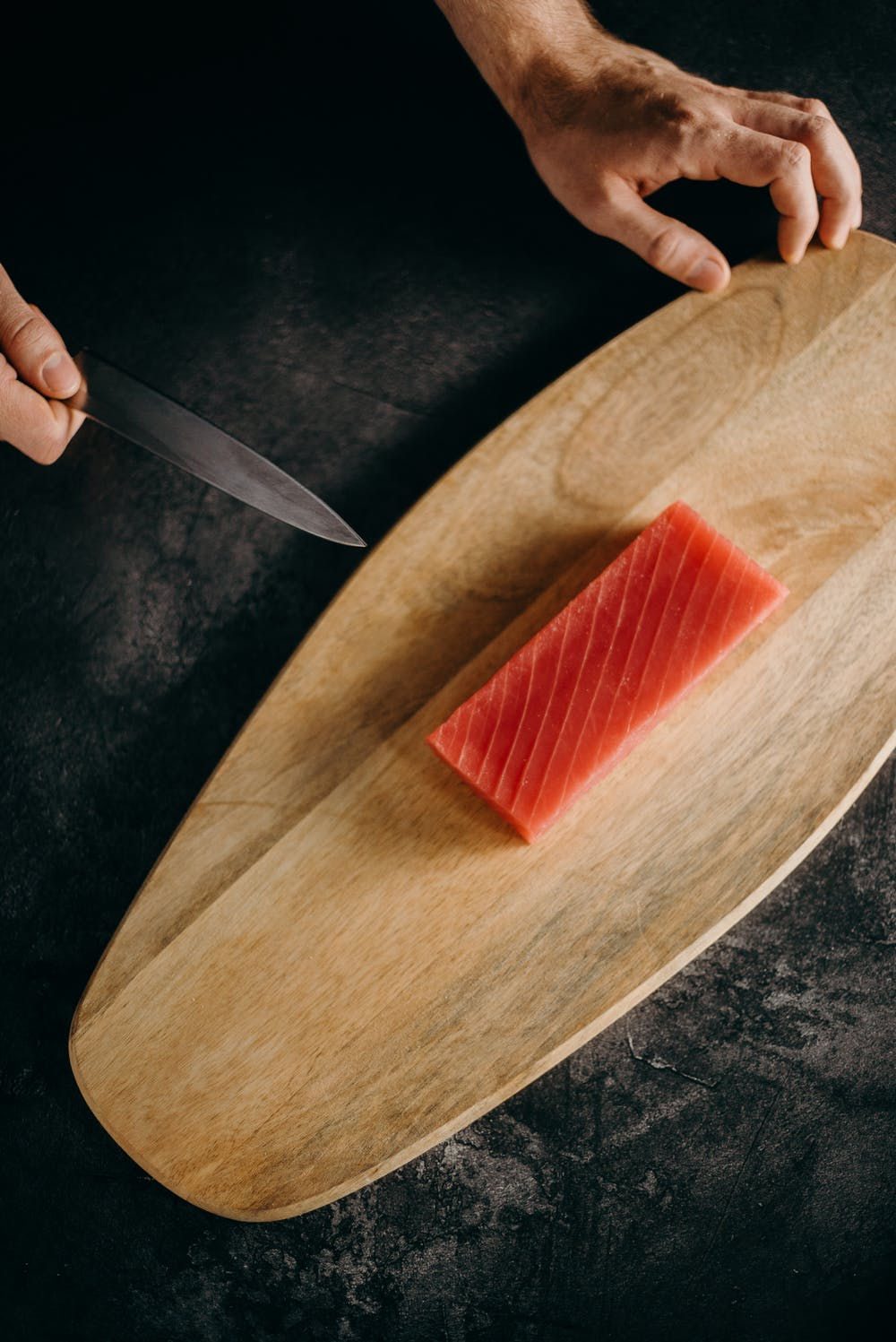 Yellowfin tuna block being portioned on a board